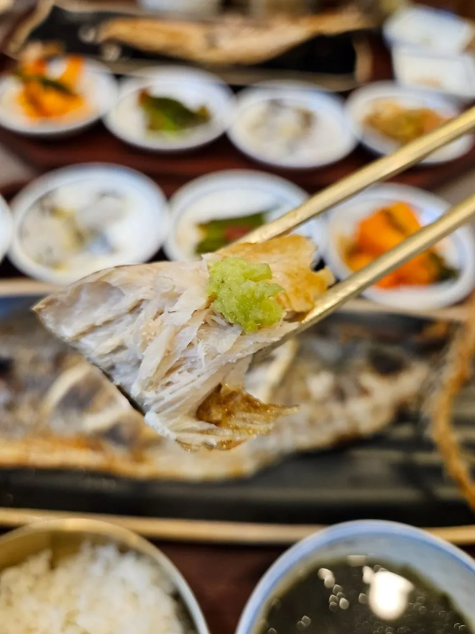 A bite of grilled fish eaten with rice