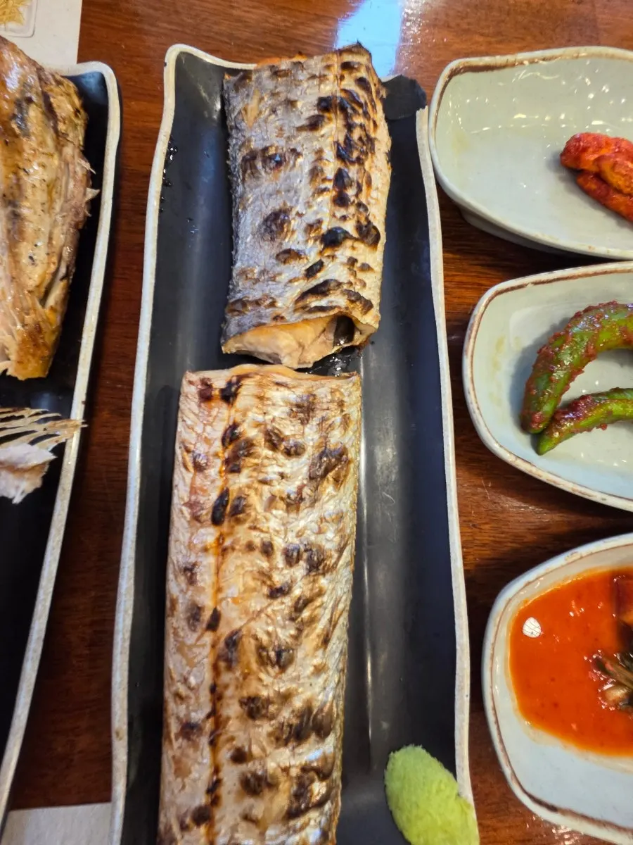 A piece of grilled mackerel dipped in wasabi soy sauce