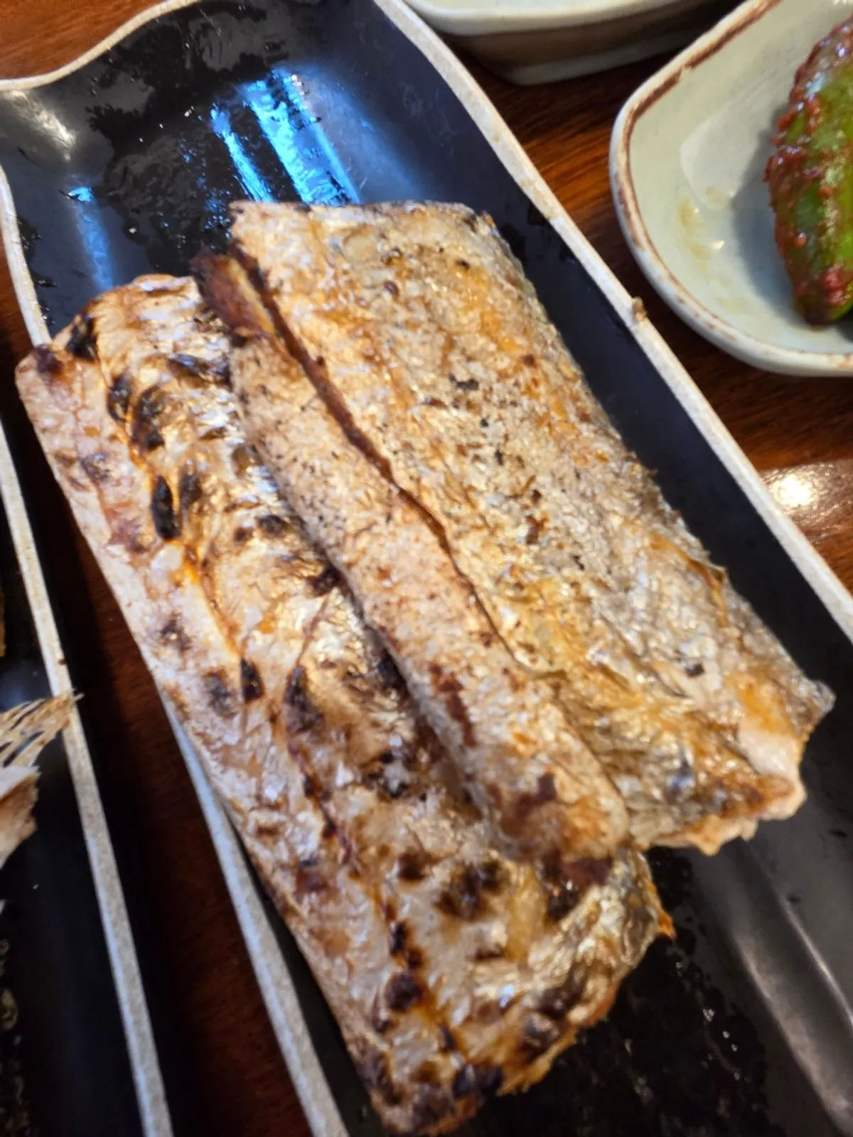 A whole grilled hairtail with silvery skin