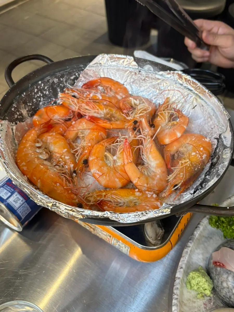 Raw shrimp cooking on a bed of salt