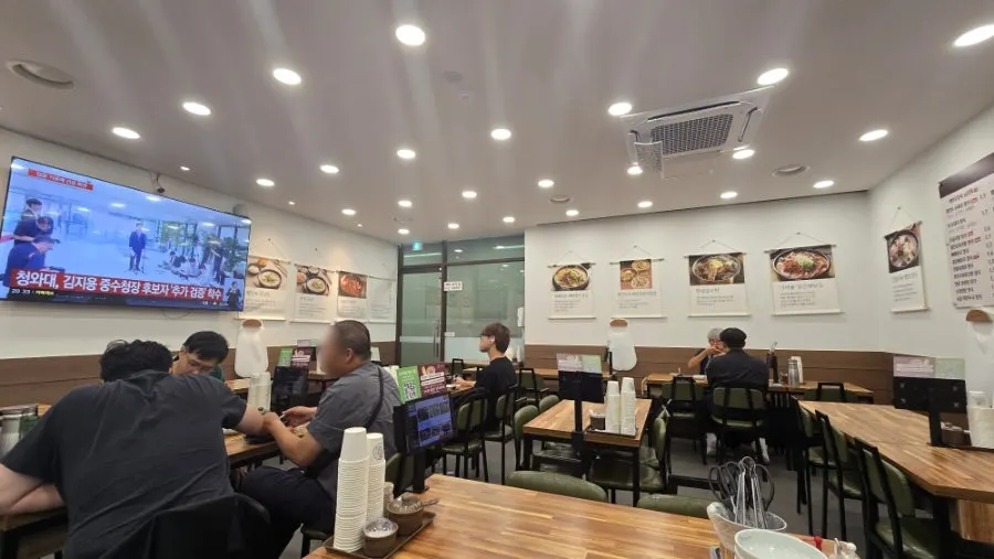 Interior of Pyeongando Restaurant Hwajeong Branch with wood-toned tables