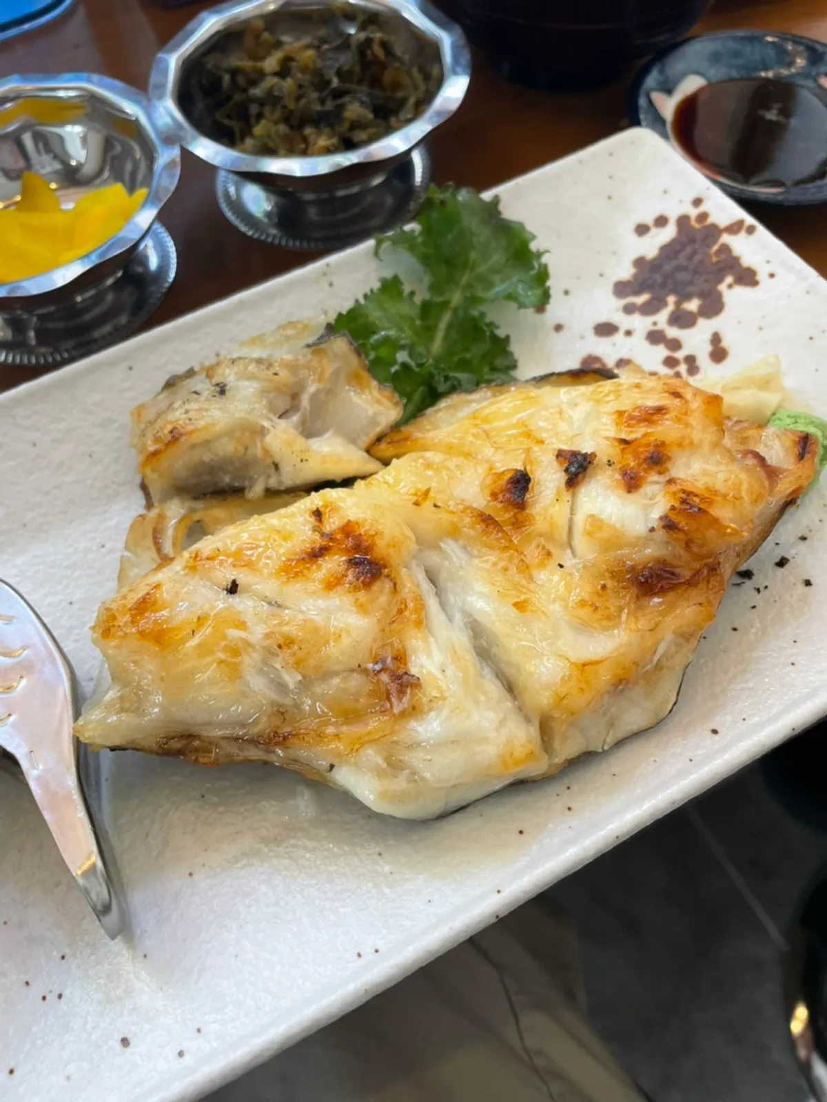 Thick salt-grilled black cod served at the table