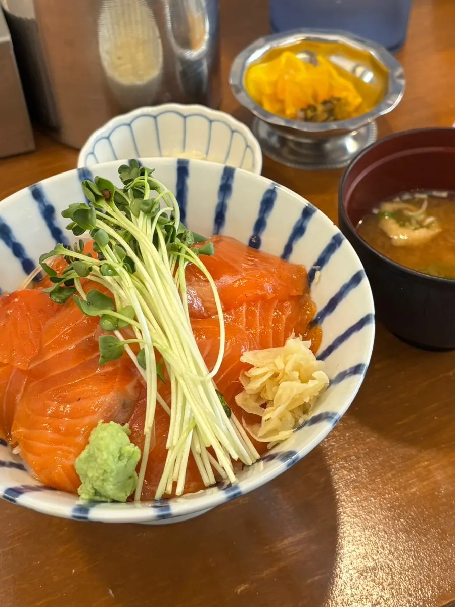 A bowl of sake-don raw salmon rice bowl served quickly
