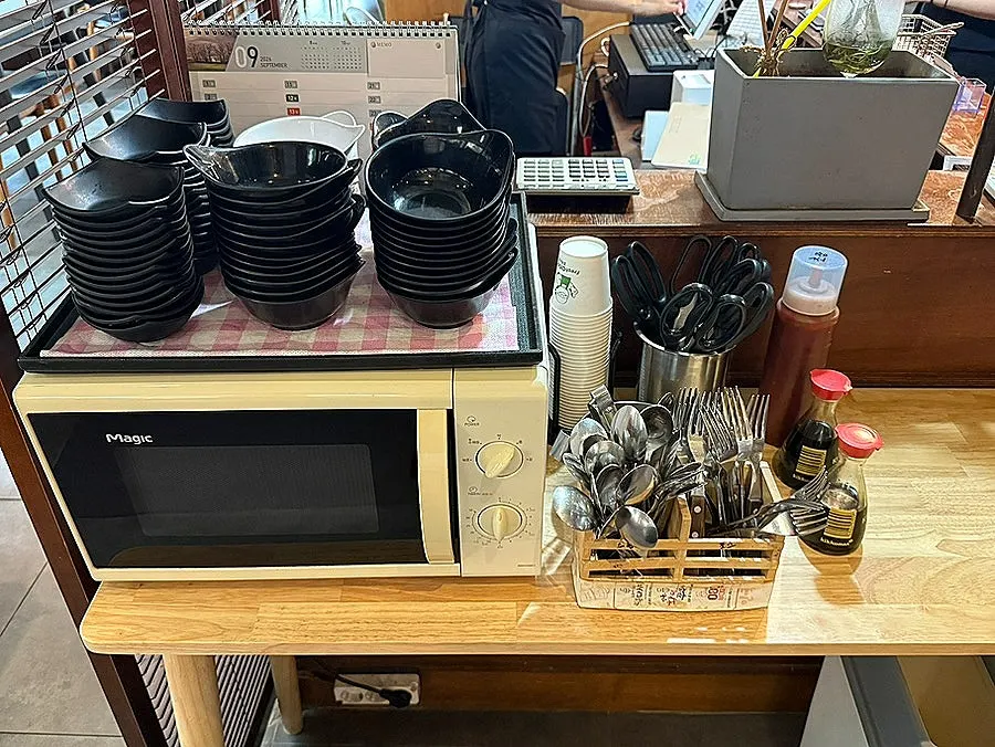 Self-serve bar with plates, utensils and sauces