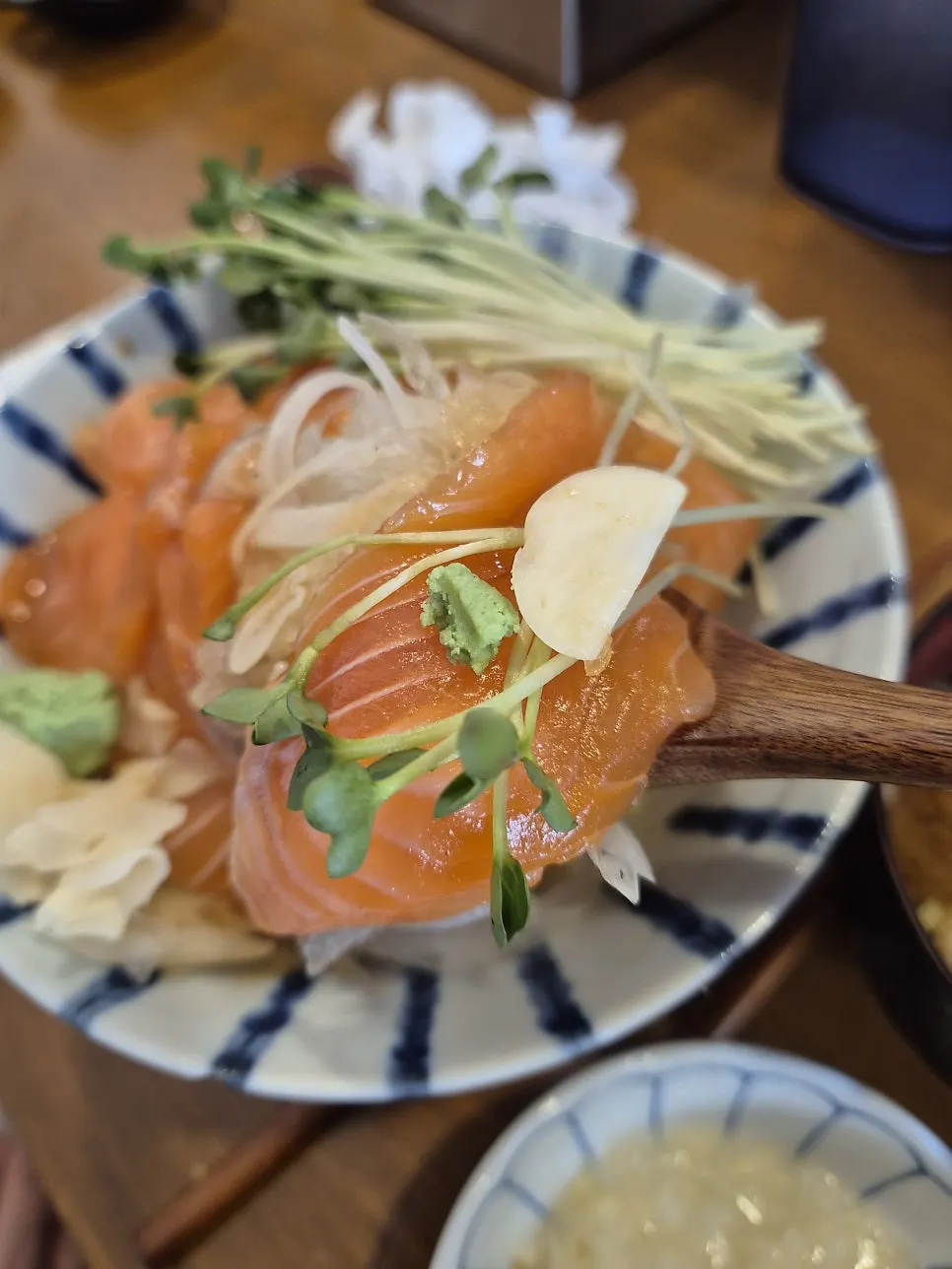 A spoonful of sake-don with pickled ginger