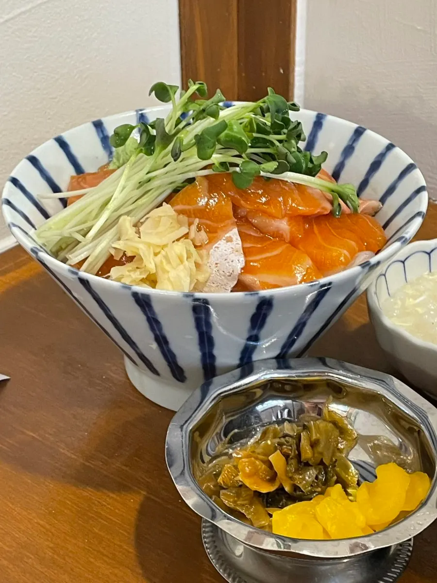 Salmon rice bowl topped with radish sprouts and wasabi