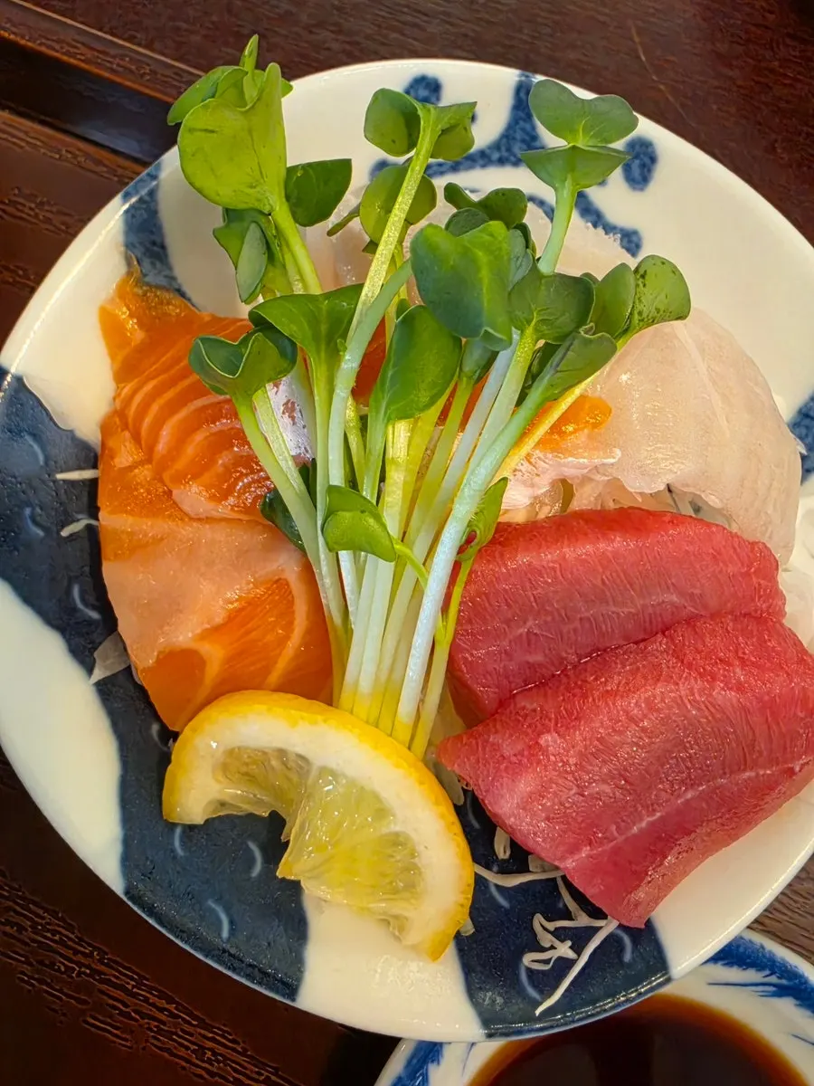 Sushi topped with green onion, sesame seeds, and thick raw fish