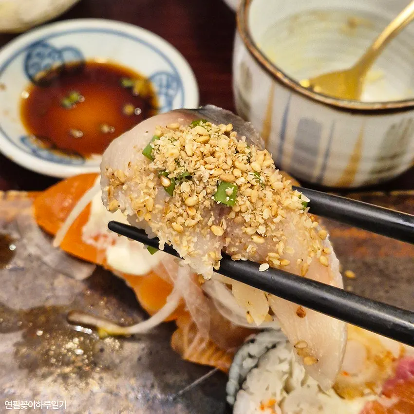 Tuna sushi topped with scallion and special sauce