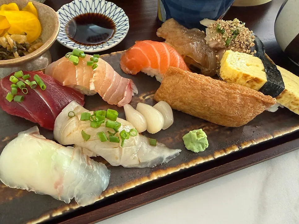 Sushi plate topped with a variety of fish including salmon and tuna