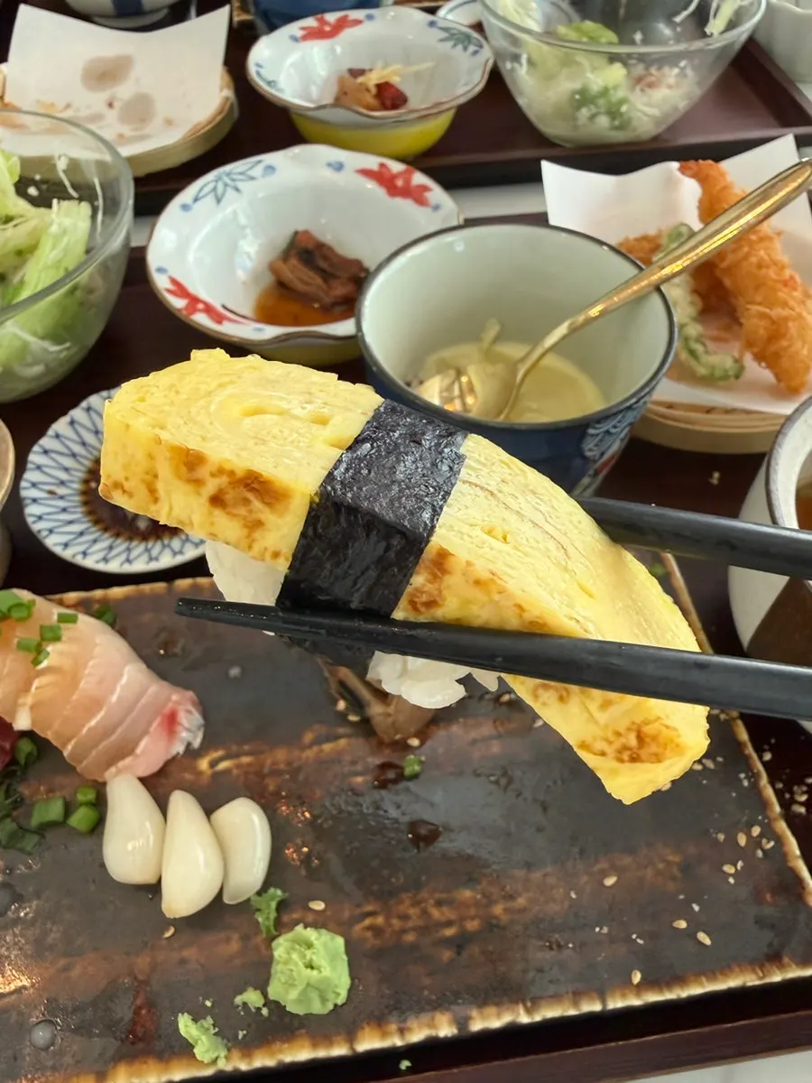 A piece of sushi picked up with chopsticks