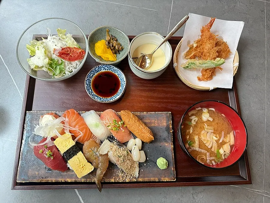Sushi set spread with sushi, tempura, salad, and soup