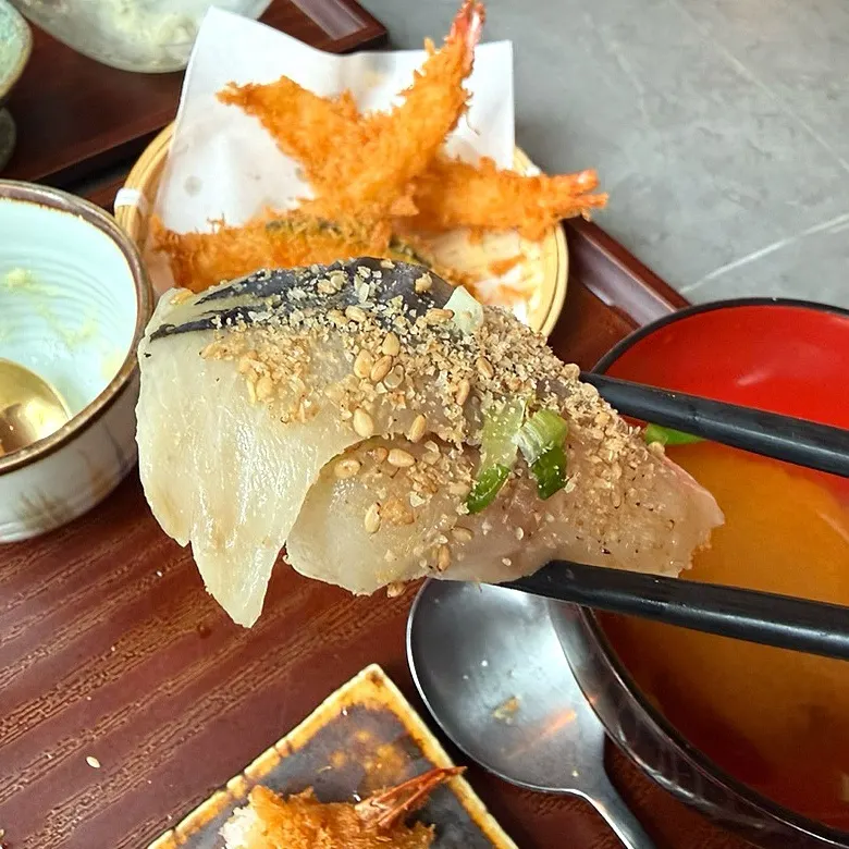 Thick tuna sushi topped with scallion garnish