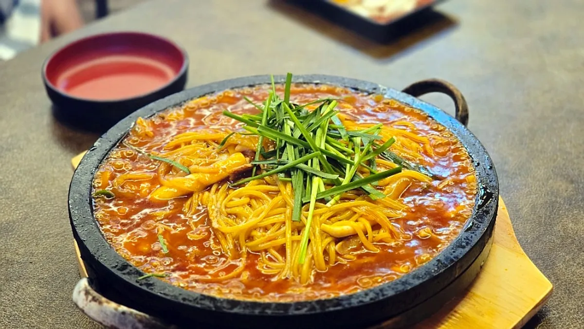Spicy noodle dish served on a hot stone plate