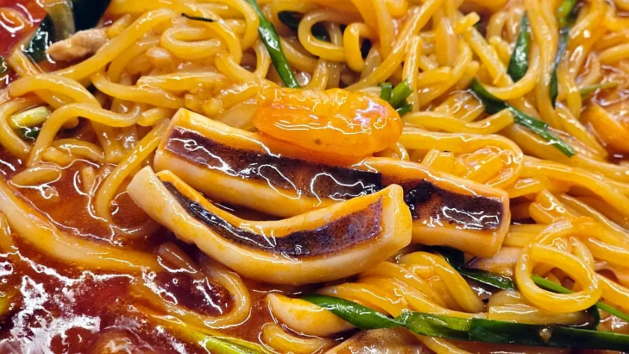 Stone-plate dish with chives over red sauce