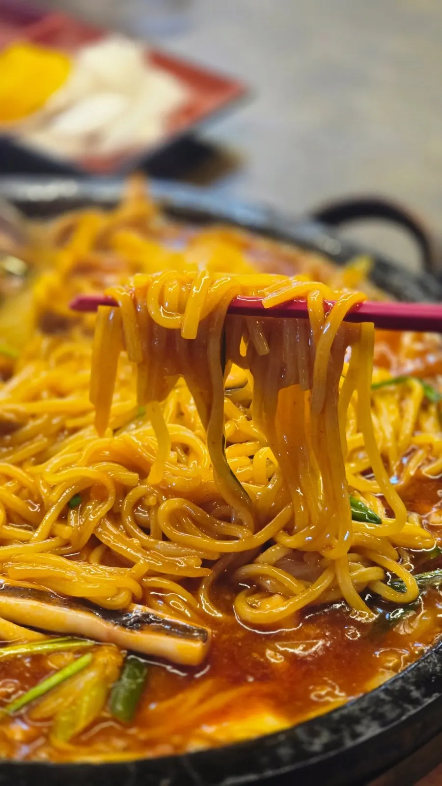Long noodles lifted with chopsticks
