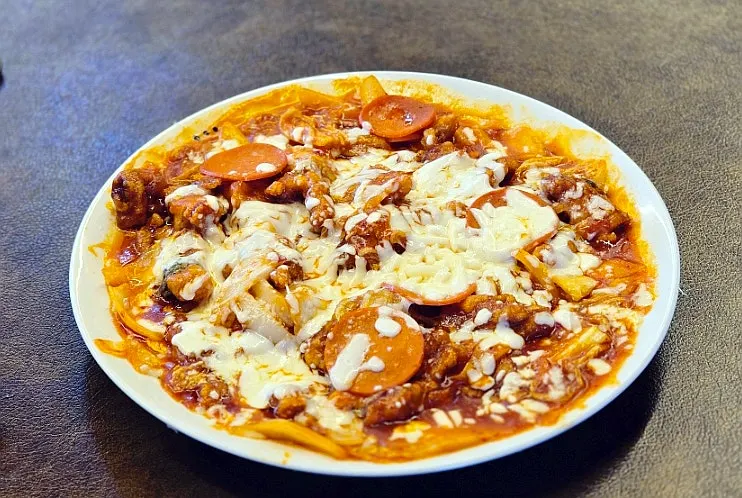 Kimchi pizza tangsuyuk topped with cheese and pepperoni
