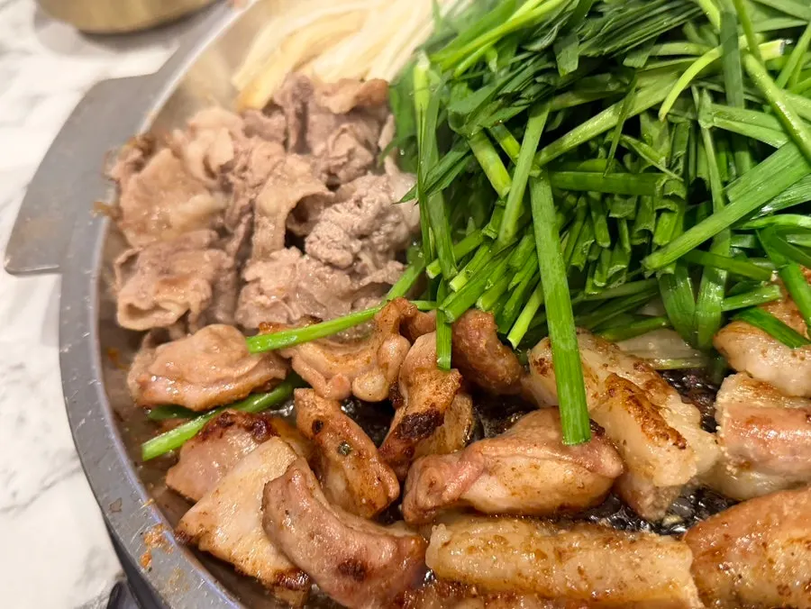 Gopchang, daechang, and beef heart grilling together on the pan
