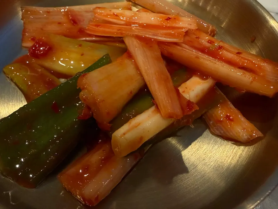 Self-serve bar with green onion kimchi and mukeunji