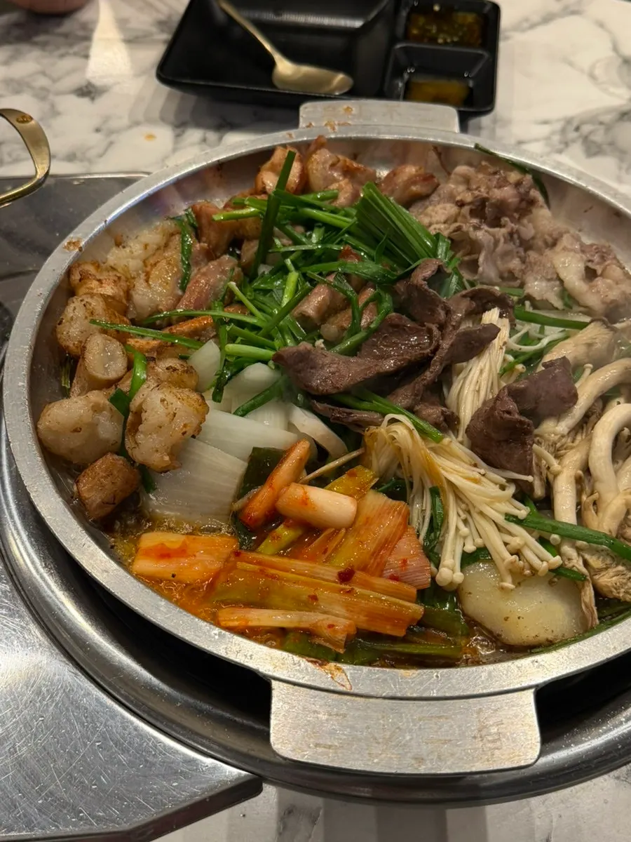 Adding scallion kimchi to the grill as an extra topping
