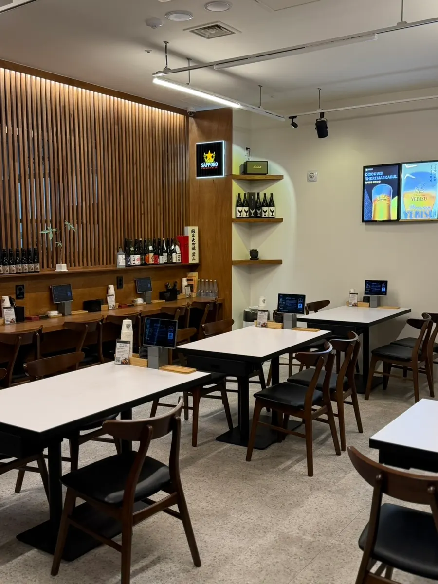 우드 인테리어와 흰색 테이블의 황제초밥 일산본점 내부