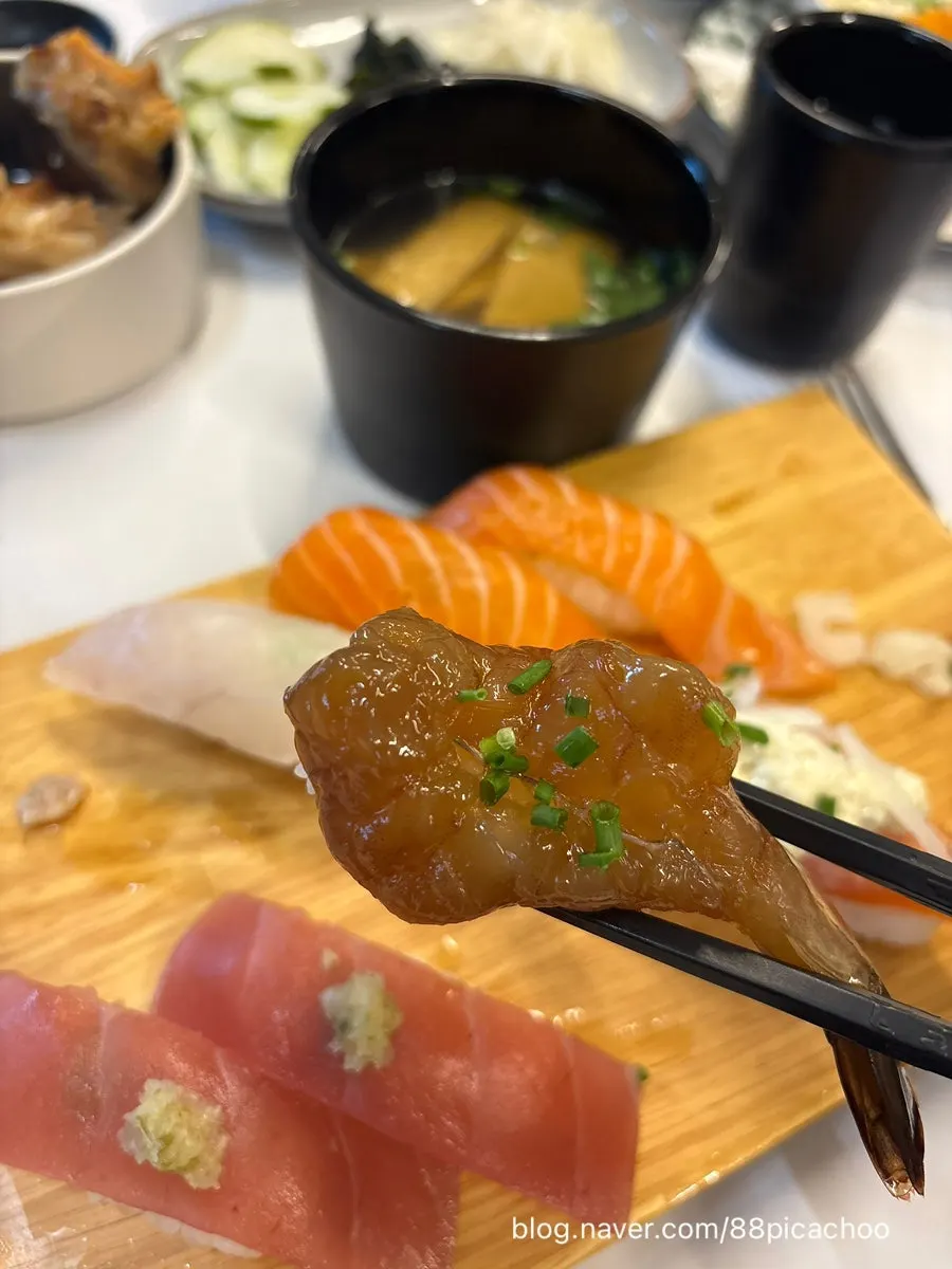 A piece of sushi with a thick fish slice