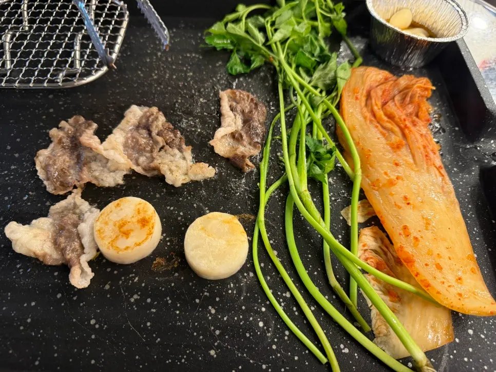 Beef brisket and scallop grilling slowly on the grill plate