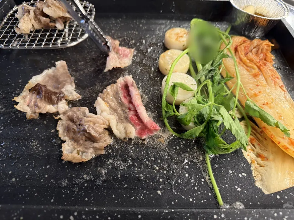 Grill plate with minari and napa cabbage kimchi being grilled together