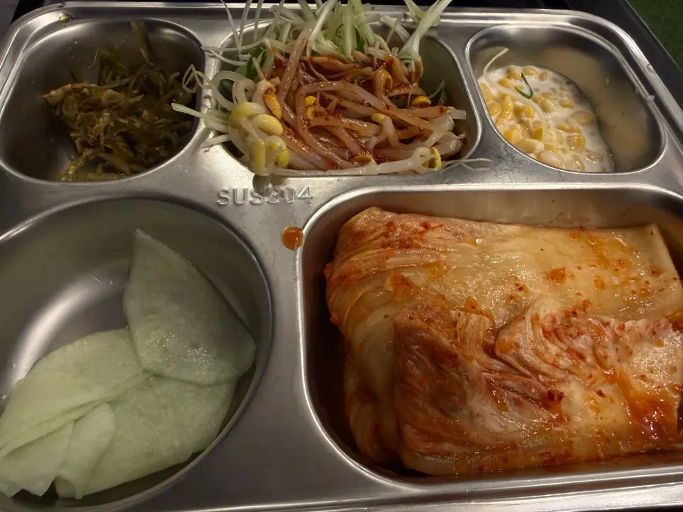 Basic side dishes of kimchi, bean sprouts, and pickled peppers