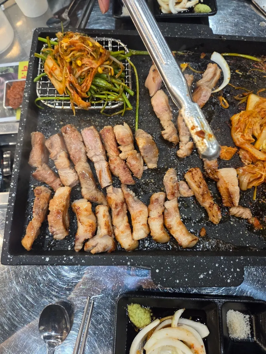 Minari laid over pork belly on the grill plate
