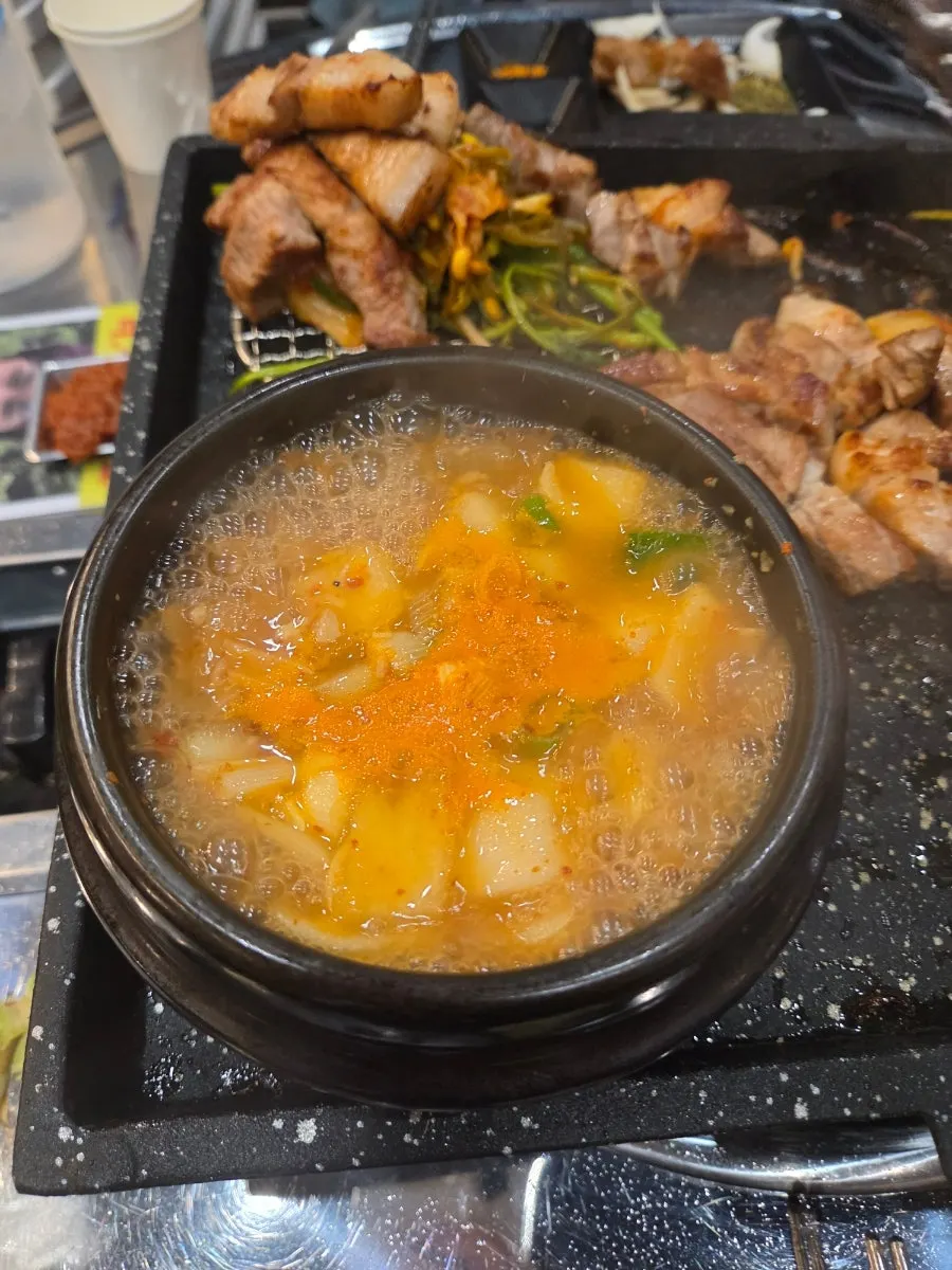 Picking up a bite of grilled meat with minari