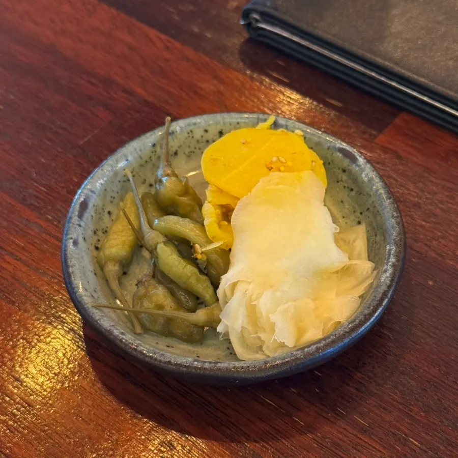Side dishes of pickled ginger, danmuji, and pickled chili peppers