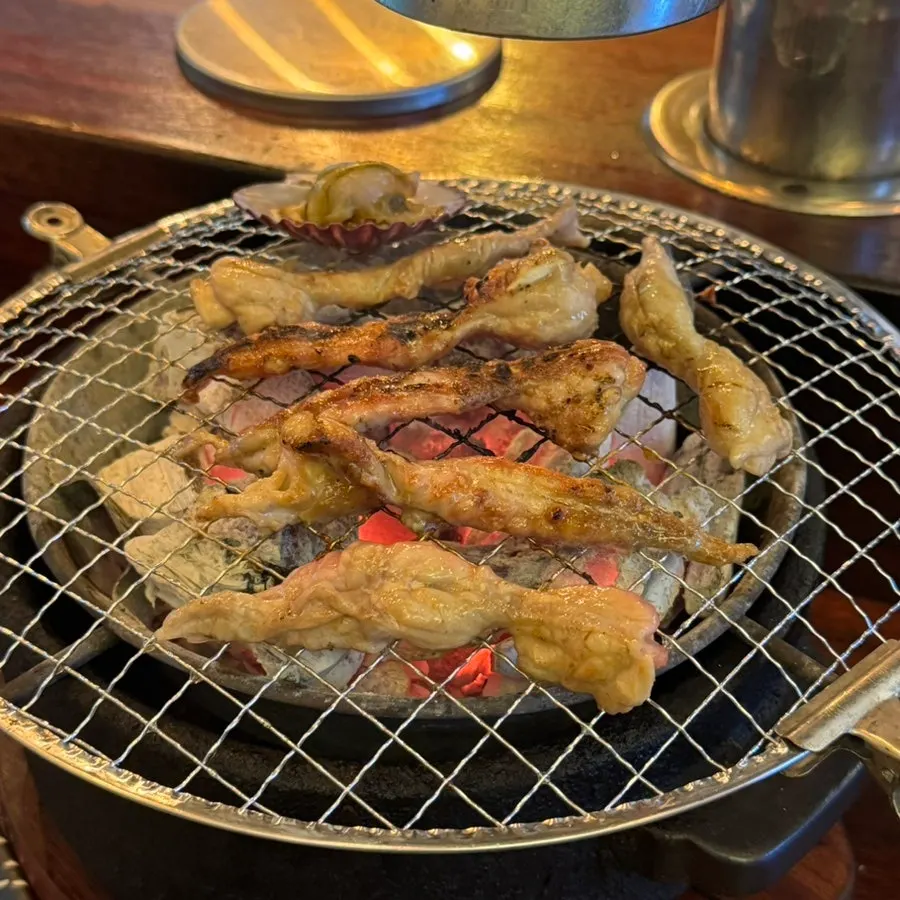 Scallops and seasoned chicken thigh on the grill