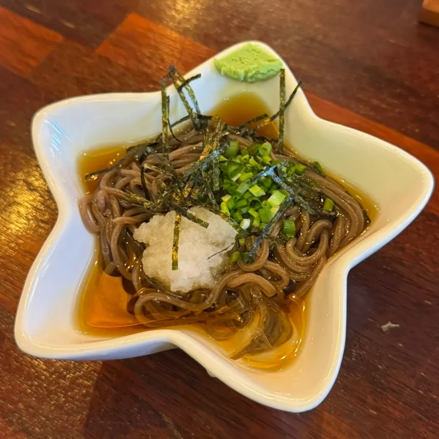 Buckwheat noodles served with grated radish, seaweed flakes, and chives