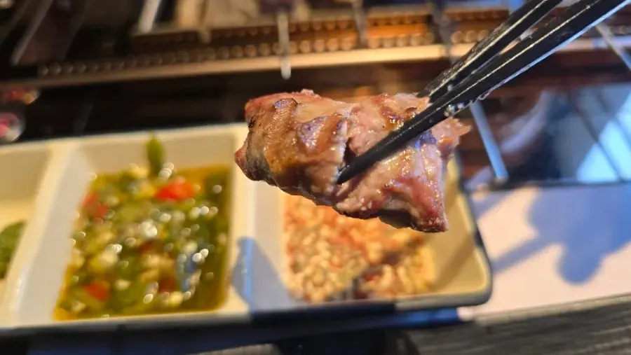 Thick lamb skewers browning over charcoal
