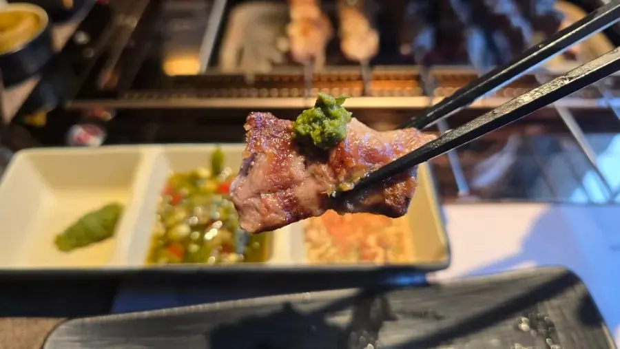 A piece of lamb skewer topped with wasabi