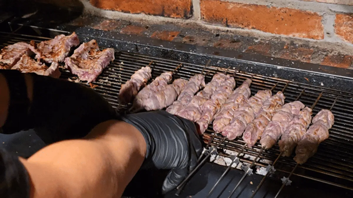 Pre-grilled lamb brought out to the table
