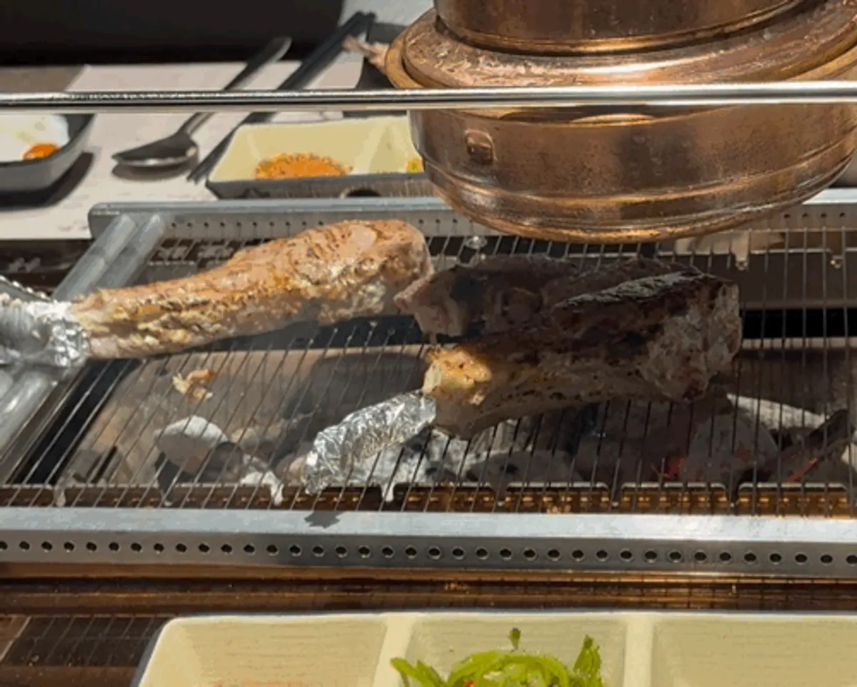 Staff grilling lamb at the table