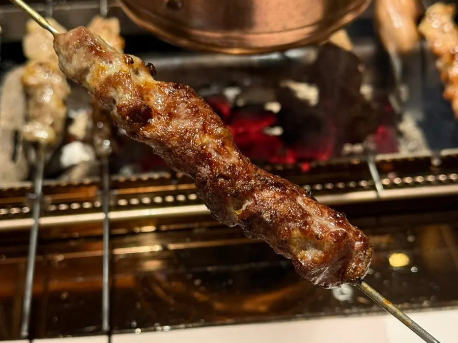 Large lamb sirloin skewers cooking over the charcoal grill