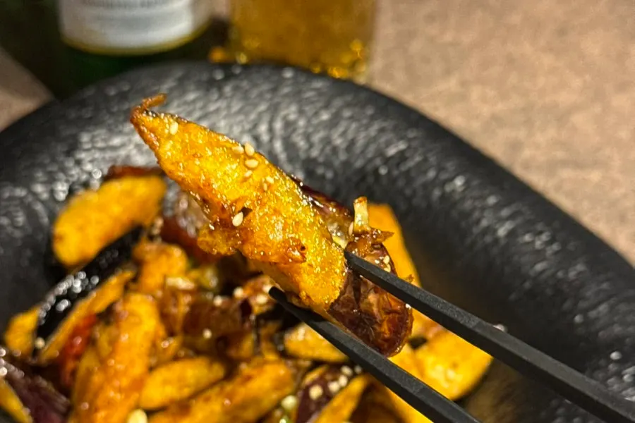 A crispy-battered piece of eggplant fritter