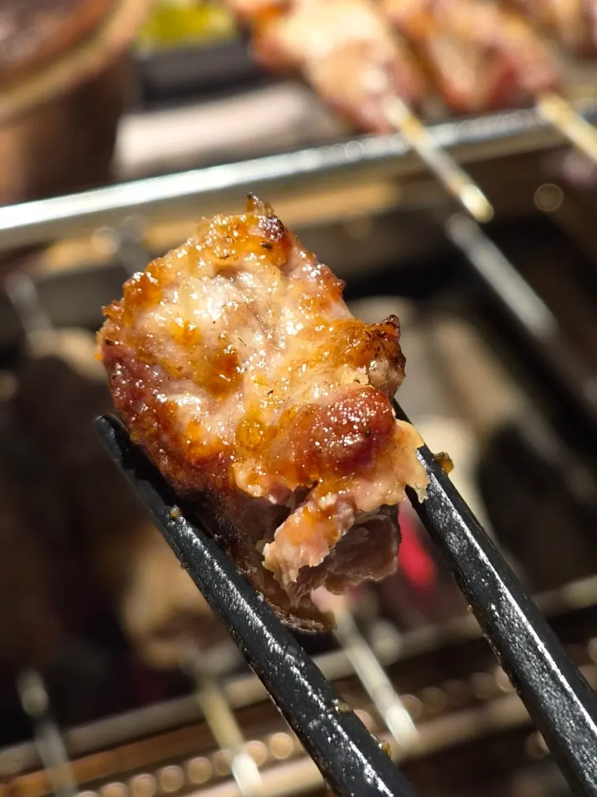 Thick lamb skewers cooking over charcoal