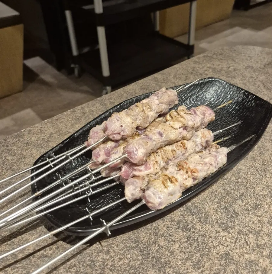 Thick lamb skewers placed over the charcoal
