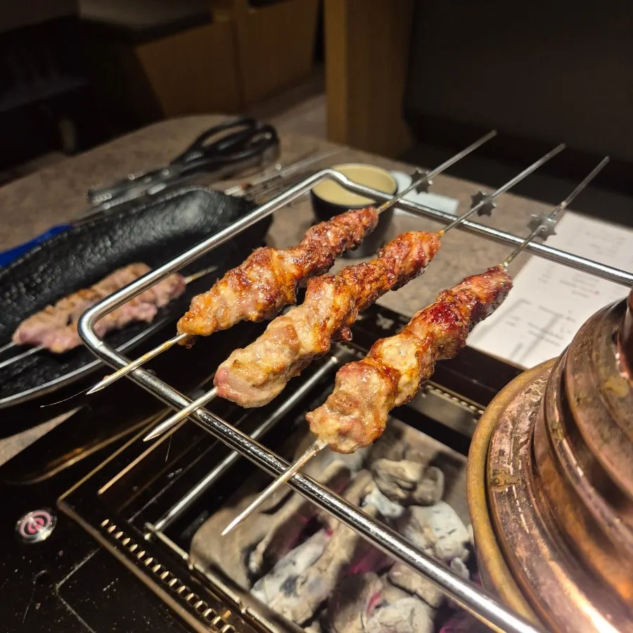 Young lamb thick skewers grilling to a golden brown