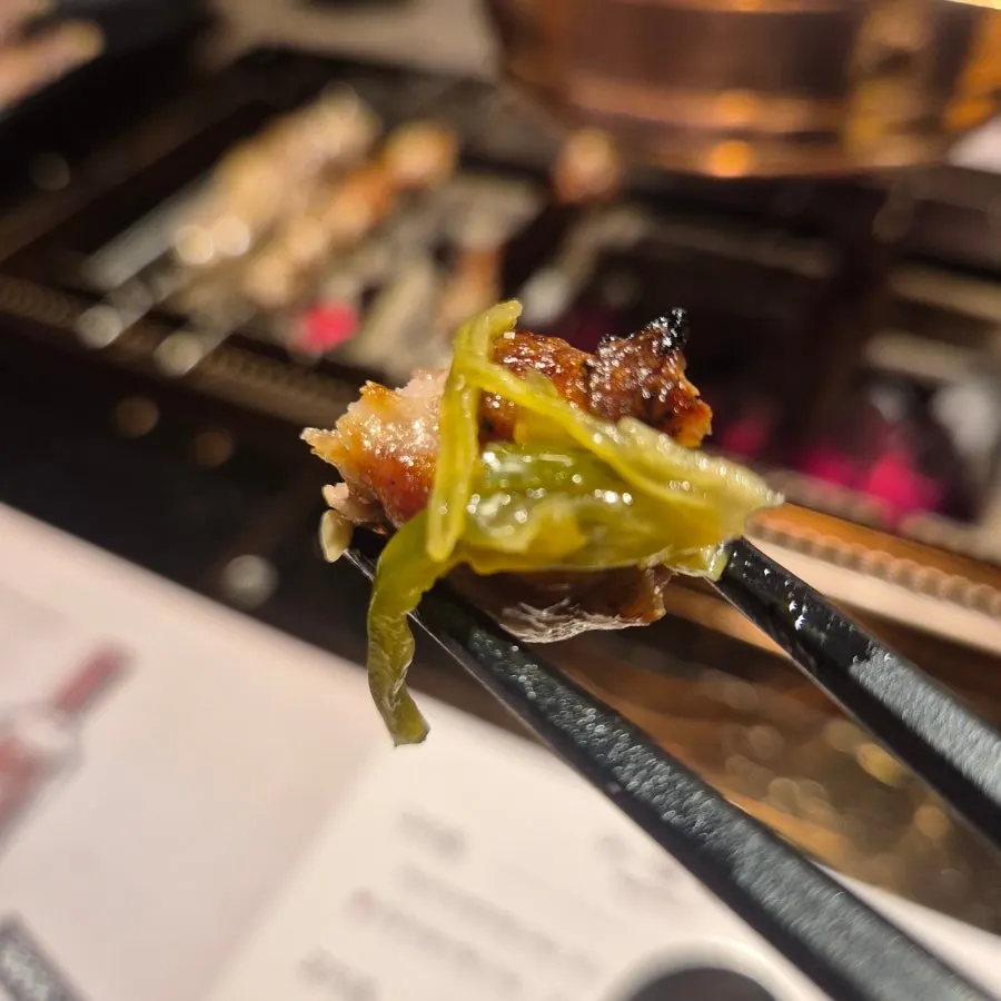 Lamb skewers over charcoal with sauce plate