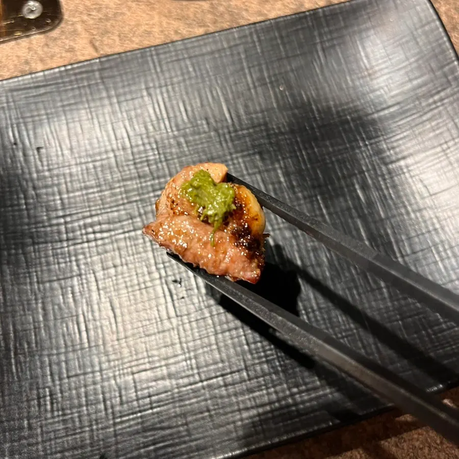 A piece of lamb chop topped with chili pepper