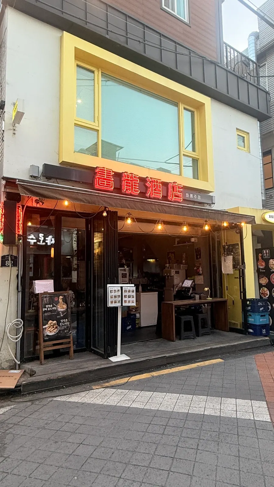 빨간 조명이 켜진 화룡주점 간판