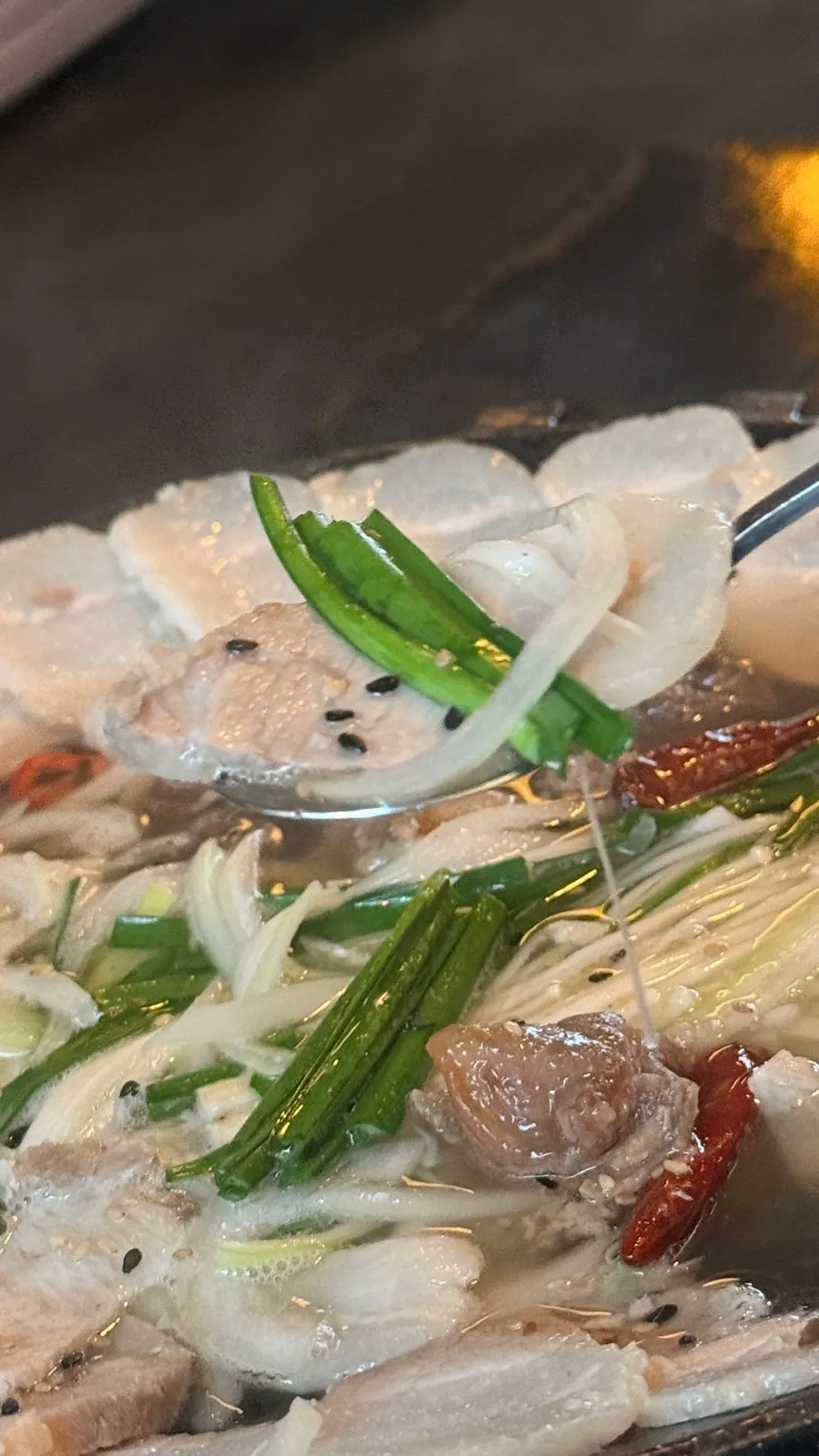얇게 썰린 전골 수육 한 점
