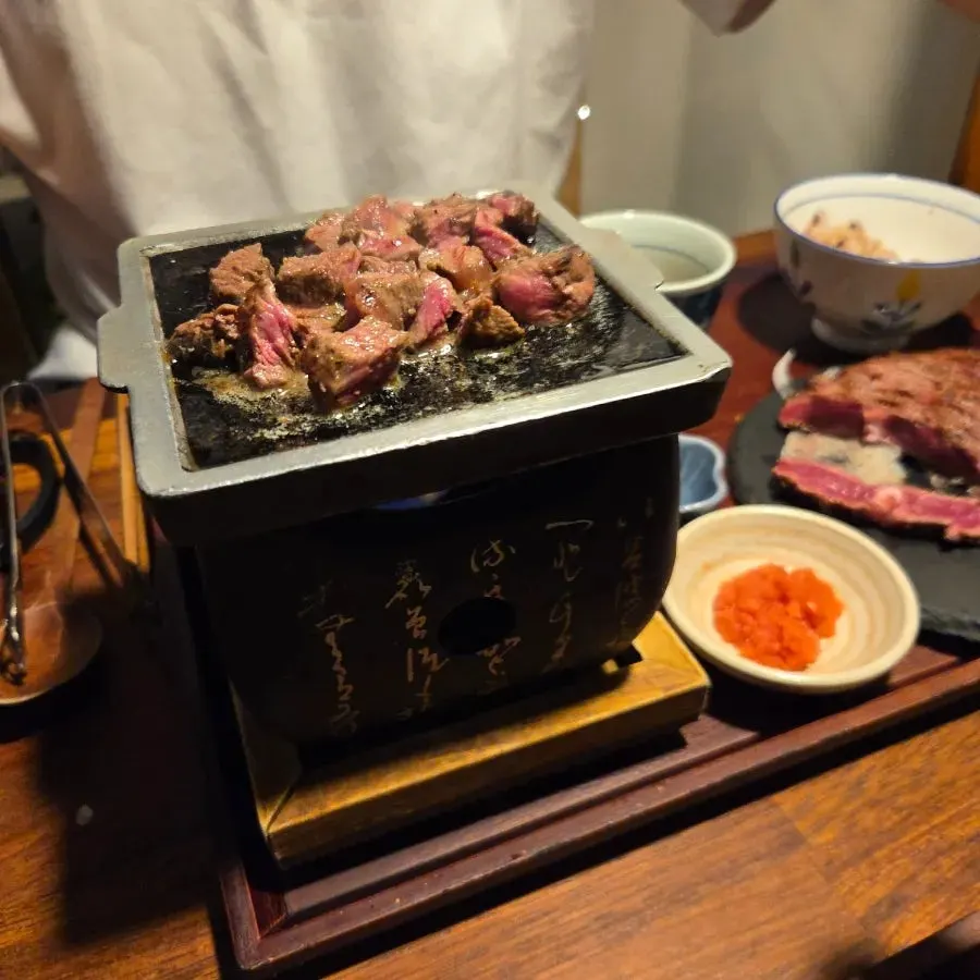 Soup stock and rice served alongside the steak hwaro-gui