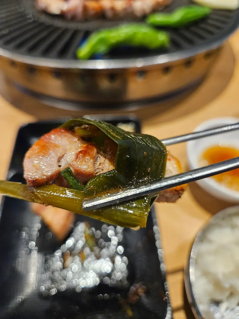 A piece of pork belly topped with scallion salad