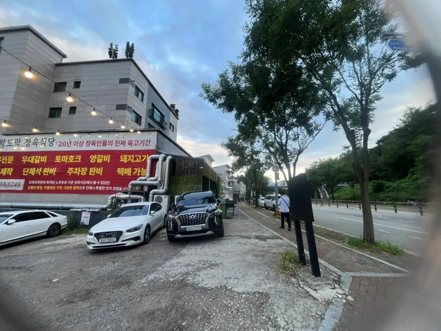 View of the Hwaseong butcher restaurant with large parking lot and group seating