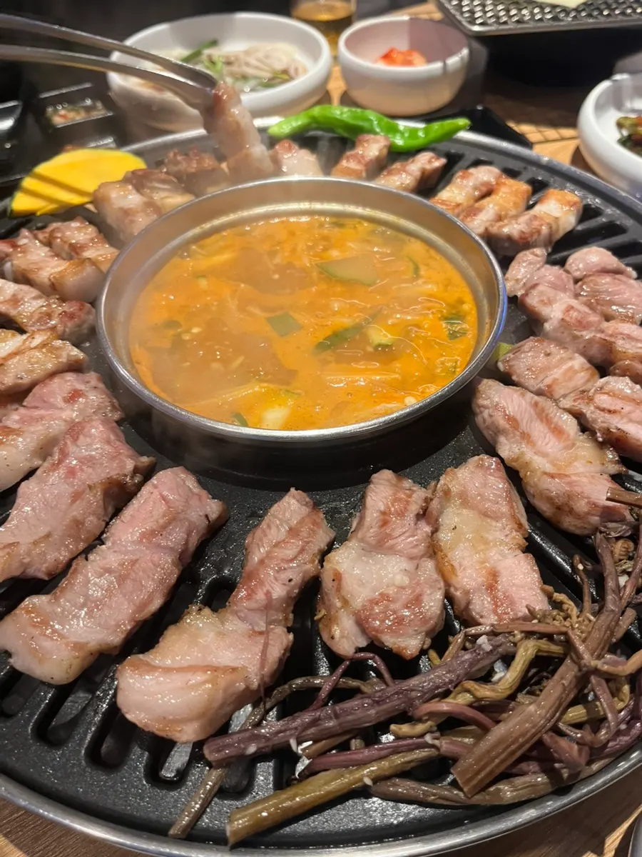 Grill loaded with charcoal pre-grilled pork belly and pork neck
